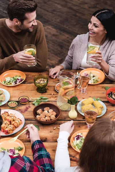 Pessoas jantando na mesa rústica — Fotografia de Stock
