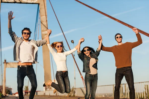 Cheerful people holding hands and jumping — Stock Photo, Image