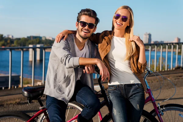 Jovem casal inclinado em suas bicicletas — Fotografia de Stock