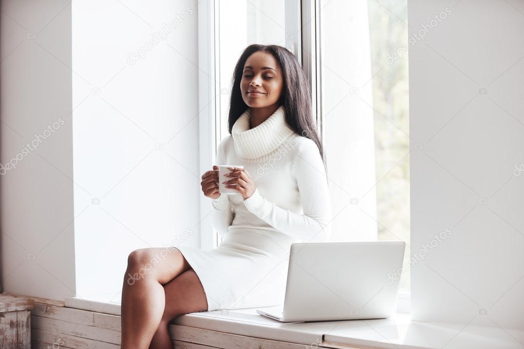 African woman holding coffee cup