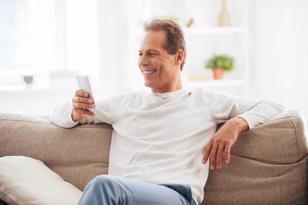 Glad mogen man håller mobiltelefon — Stockfoto