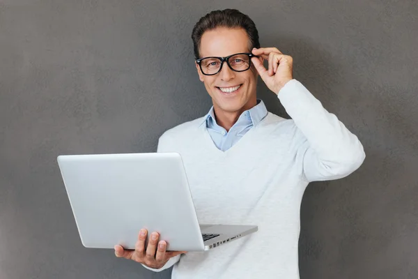 Zelfverzekerde volwassen man bedrijf laptop — Stockfoto