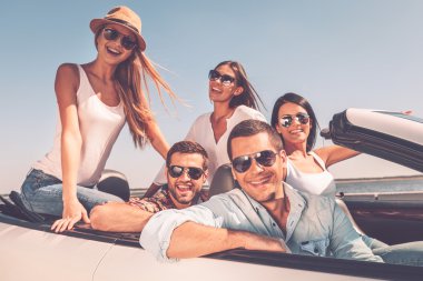 happy people enjoying trip in convertible