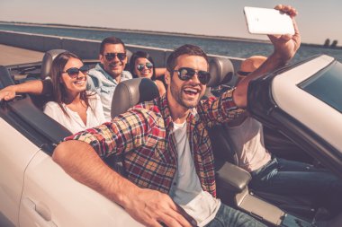 happy people making selfie in convertible