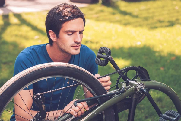 Joven que arregla su bicicleta — Foto de Stock