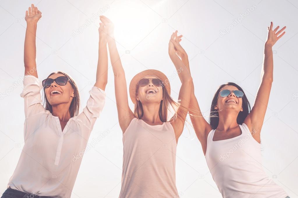 women holding hands and raising arms up