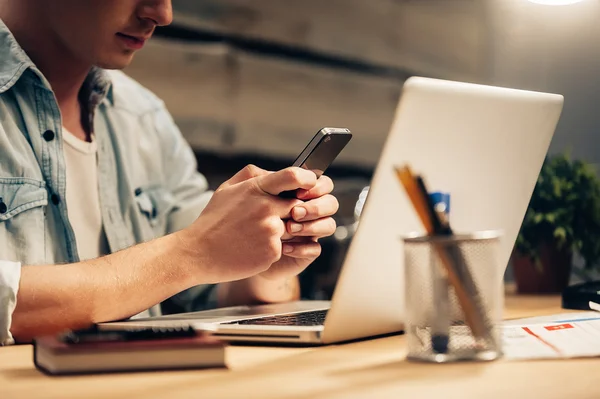 Homme avec téléphone intelligent à son lieu de travail — Photo