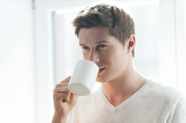 コーヒーを飲みながら陽気な若い男 — ストック写真