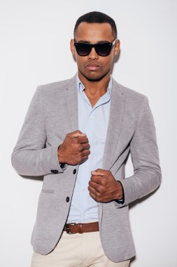 African man in sunglasses adjusting his jacket