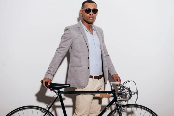 Hombre africano con gafas de sol apoyado en su bicicleta — Foto de Stock