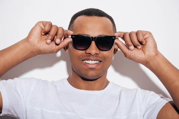 Hombre africano ajustando sus gafas de sol — Foto de Stock