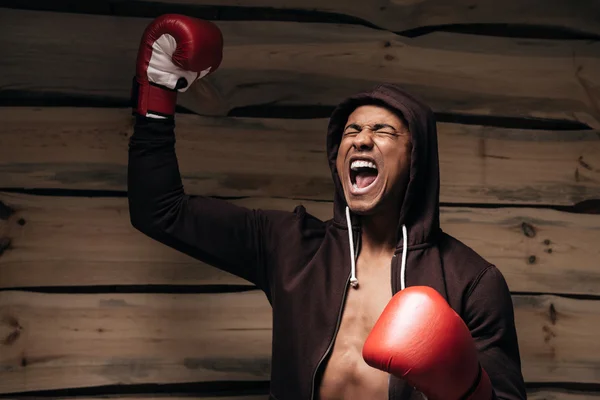 Man in hooded shirt and boxing gloves — Stock Photo, Image