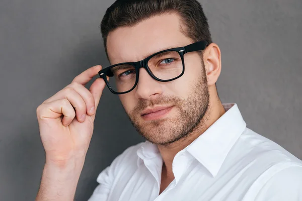 Handsome young man adjusting glasses — Stock Photo, Image