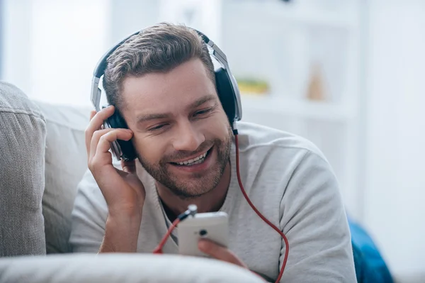 Homme dans les écouteurs écoutant la musique — Photo