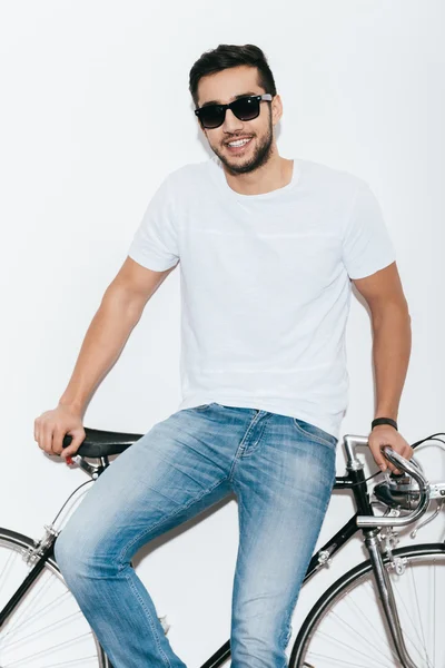Indian man in sunglasses leaning at bicycle — Stock Photo, Image