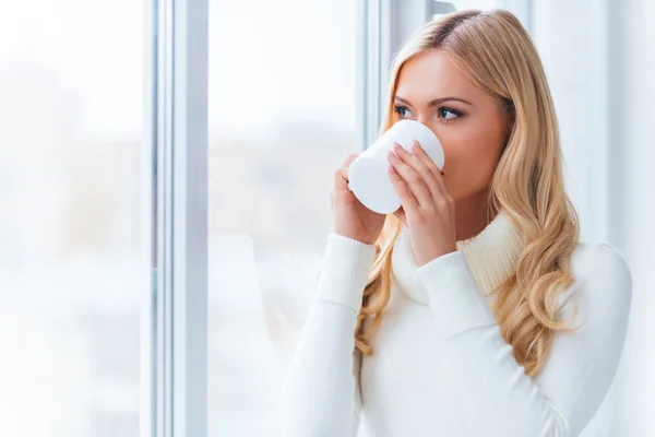 Woman in white sweater drinking coffee — Stock Photo, Image