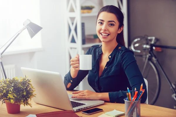 Vrouw met koffie op haar werkplek — Stockfoto