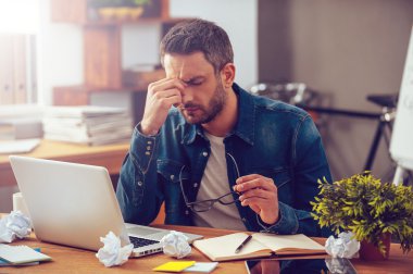 Frustrated young man  at his working place