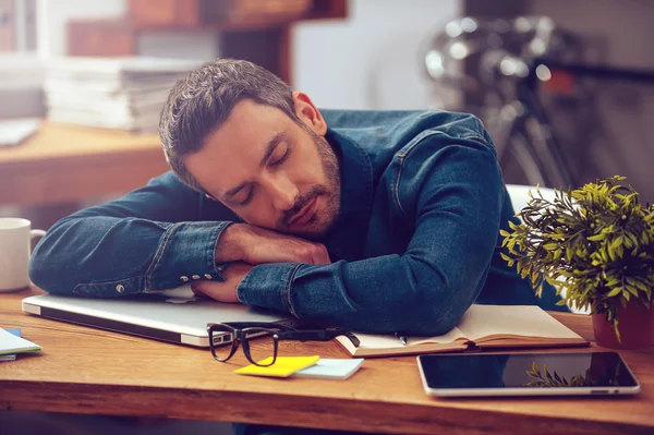 Man leaning his head on desk — Stock Photo, Image