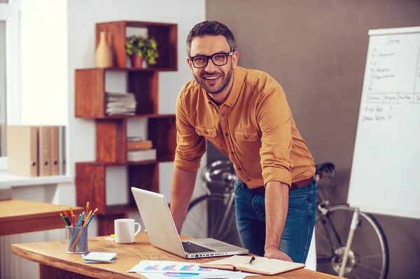 Mann steht neben seinem Arbeitsplatz im Büro — Stockfoto