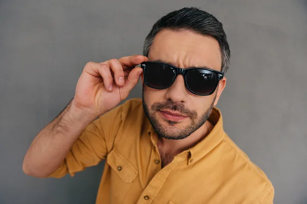 Joven guapo ajustando sus gafas de sol — Foto de Stock