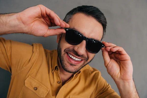Bello giovane uomo che regola i suoi occhiali da sole — Foto Stock