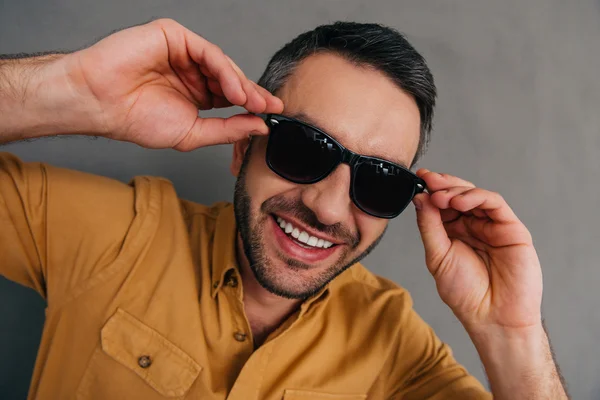 Joven guapo ajustando sus gafas de sol — Foto de Stock