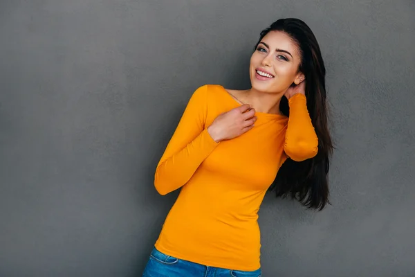 Mujer cogida de la mano en el pelo y sonriendo —  Fotos de Stock