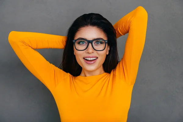 Woman holding hands behind head — Stock Photo, Image