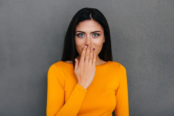 Verrast vrouw die betrekking hebben op mond met de hand — Stockfoto