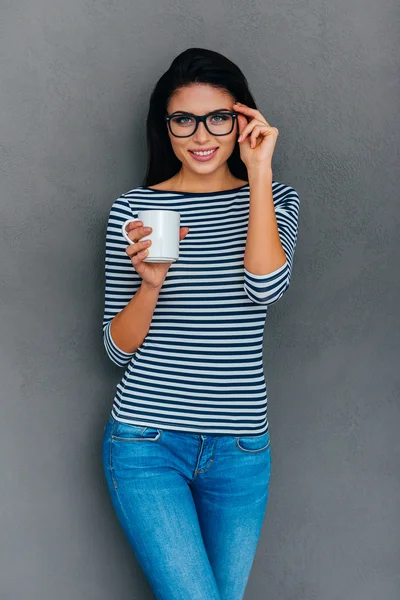 Woman holding cup and adjusting her eyeglasses — Stock Photo, Image