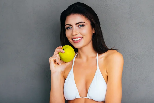 Woman in white bikini holding apple — Stok fotoğraf