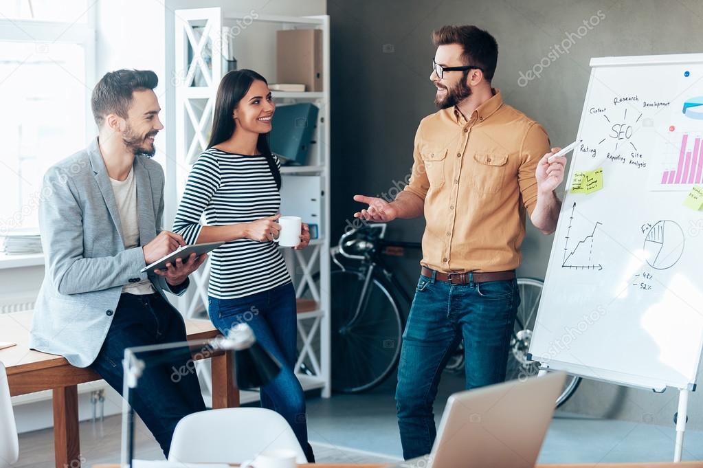 man standing near whiteboard with colleagues