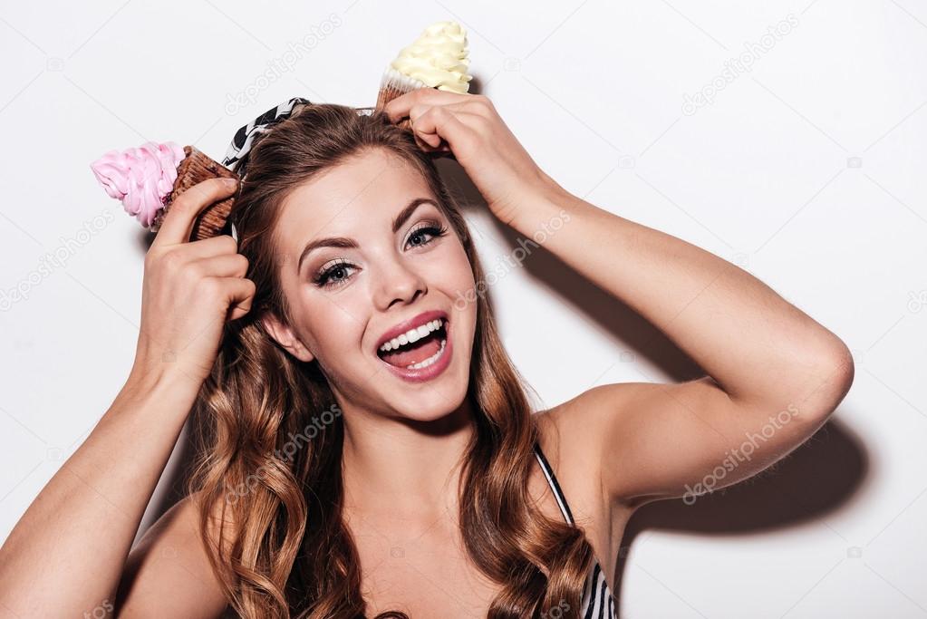 woman holding cupcakes over head