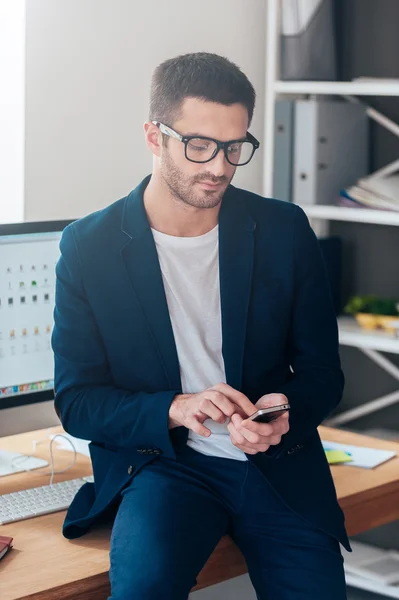 Hombre seguro sosteniendo el teléfono inteligente — Foto de Stock