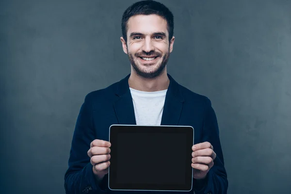 Homem alegre mostrando tablet digital — Fotografia de Stock