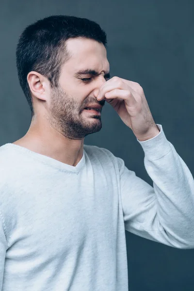 Frustrated man covering nose with fingers — Stock Photo, Image