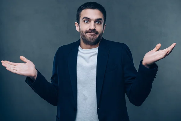 Confused man stretching out arms — Stock Photo, Image