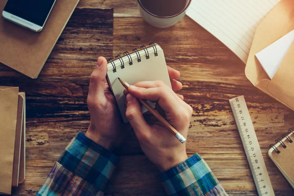 Hombre sosteniendo cuaderno y escritura — Foto de Stock