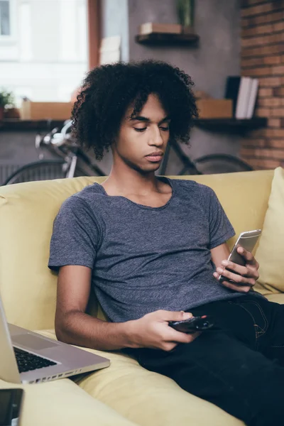 African man holding remote control — Stockfoto