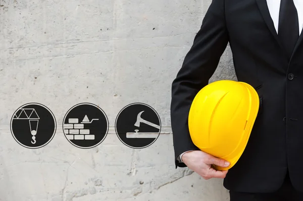 White collar worker holding hardhat — Zdjęcie stockowe