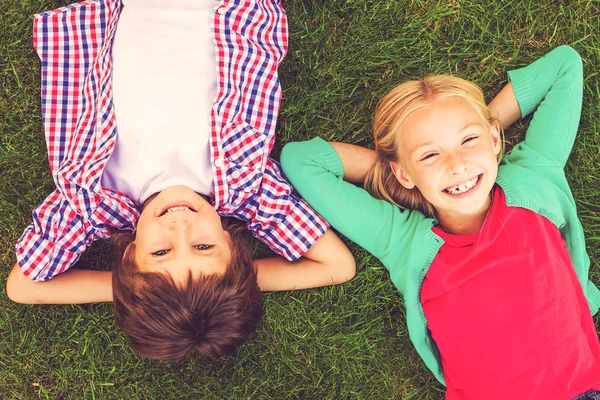 Leuke lieve kinderen liggen op gras — Stockfoto