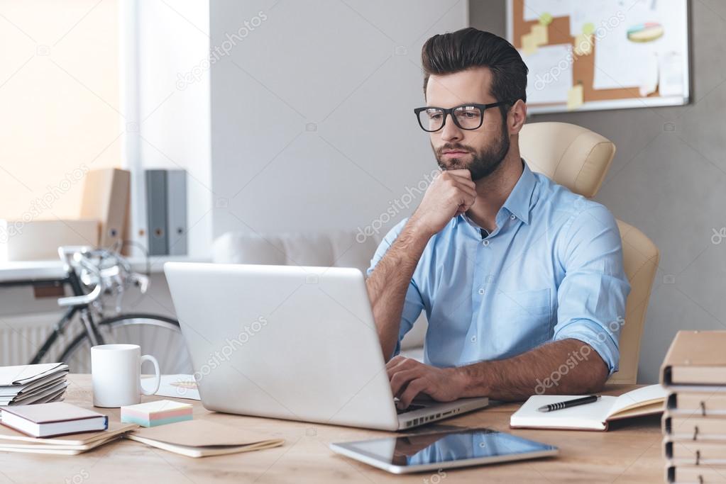 Handsome working with laptop in office