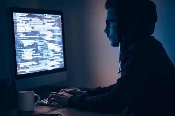 Homem no computador no quarto escuro — Fotografia de Stock