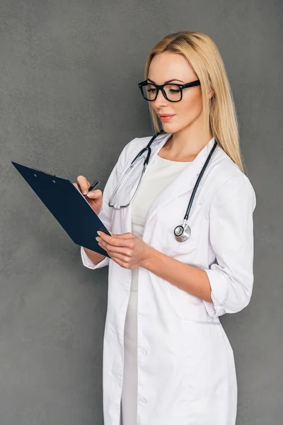 Médica feminina segurando prancheta — Fotografia de Stock