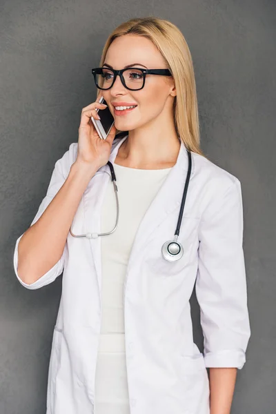 Young female doctor talking on mobile — Stockfoto