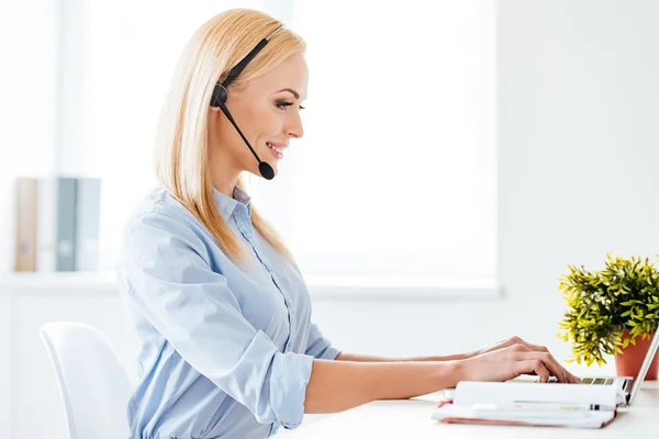 Woman in headphones working on laptop — Stok fotoğraf