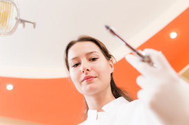 Bir şırınga tutarak diş hekimi