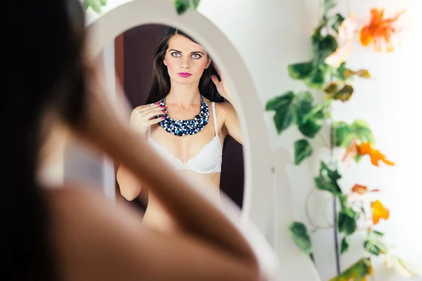 Kvinna i BH tittar i spegeln — Stockfoto