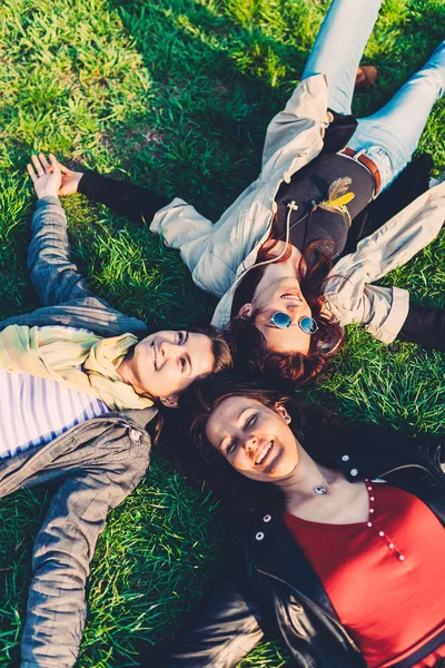 Glückliche Mädchen liegen Kopf an Kopf auf grünem Gras — Stockfoto